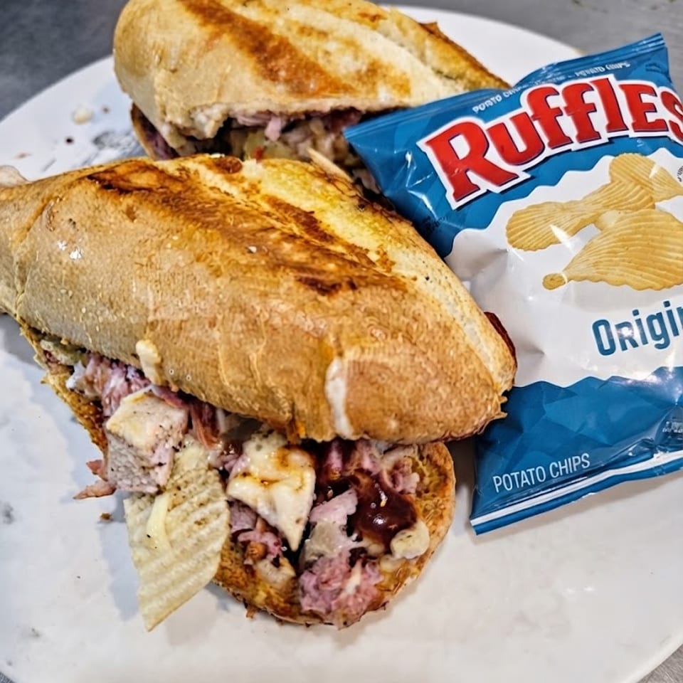 Backyard BBQ sandwich served with potato chips.